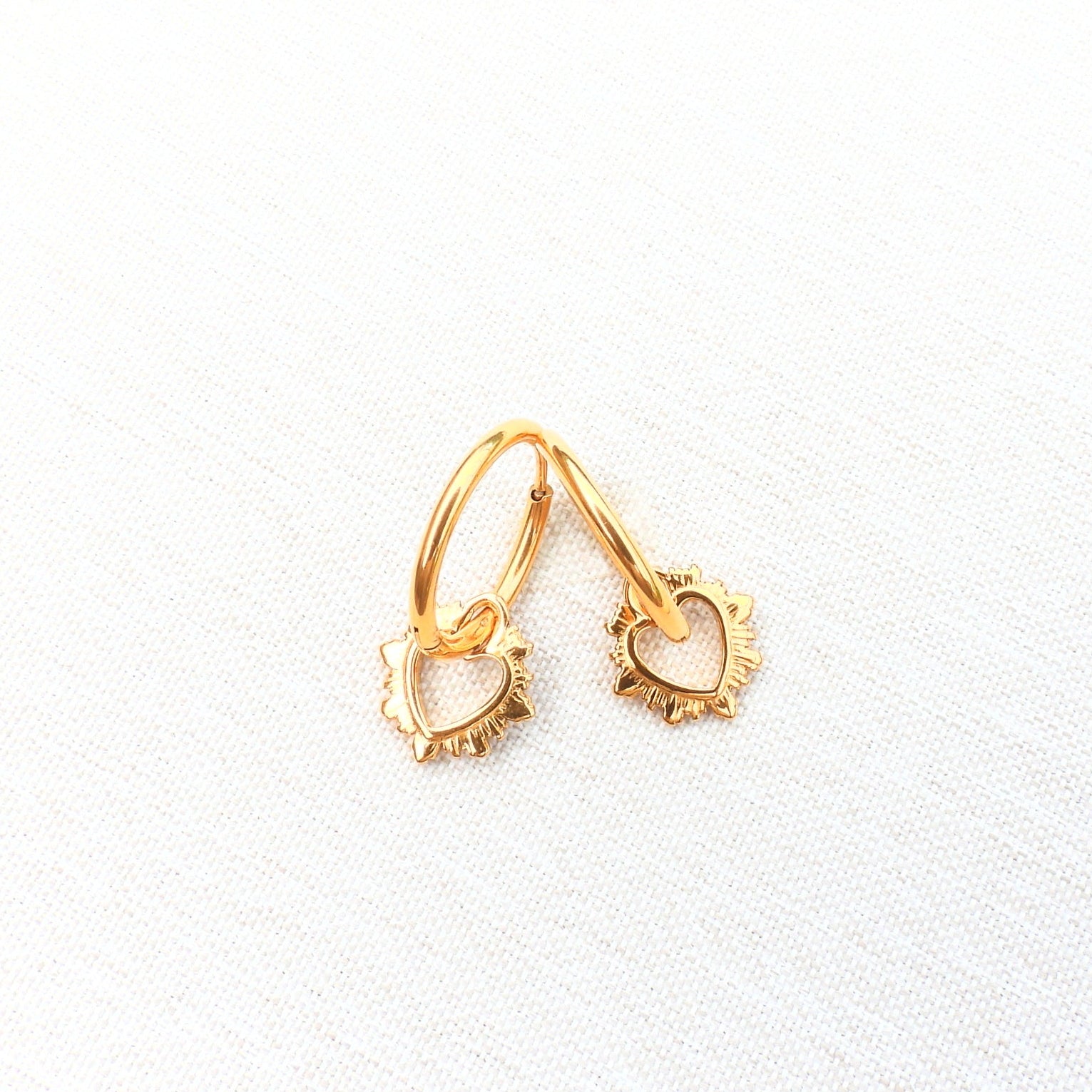 Gold earring and necklace set on a white background