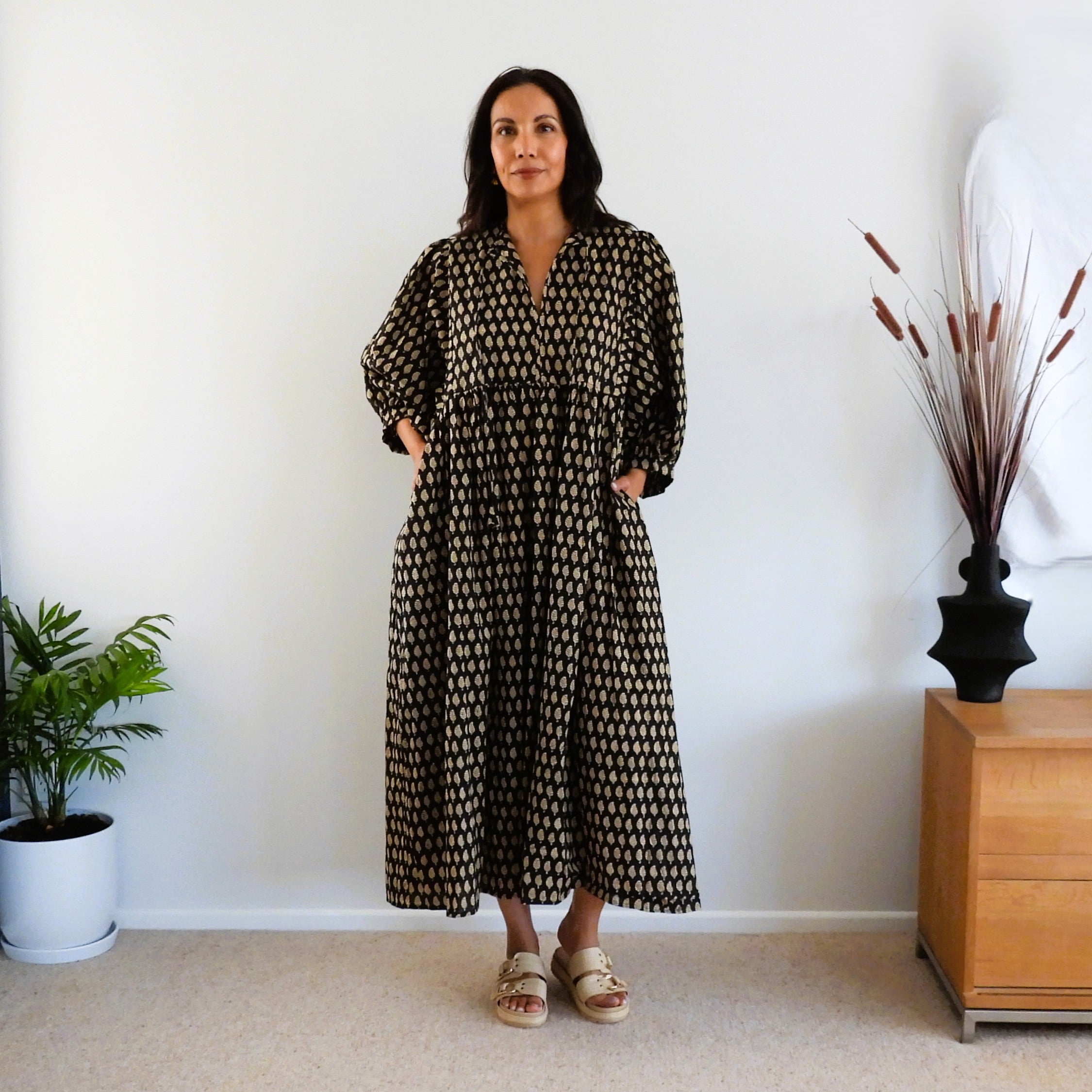 Woman in black and gold print boho dress 